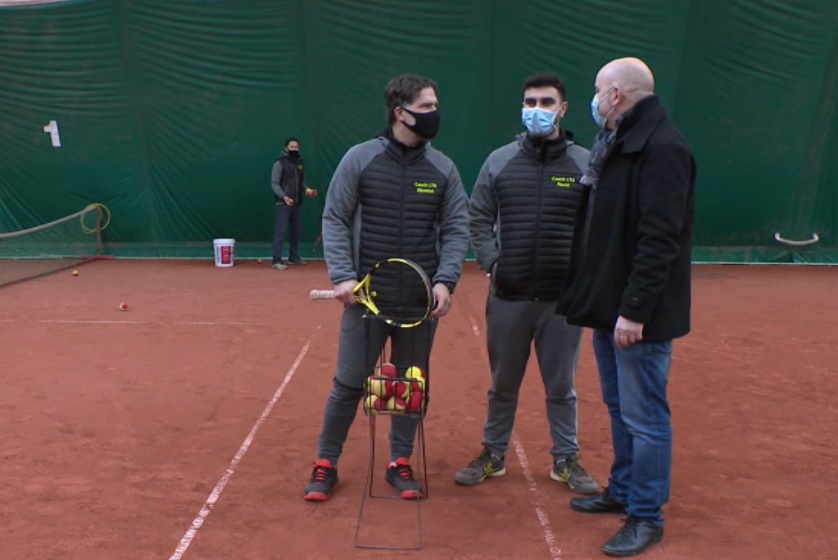 Les dirigeants du Lambermont discutent sur un terrain de terre battue.